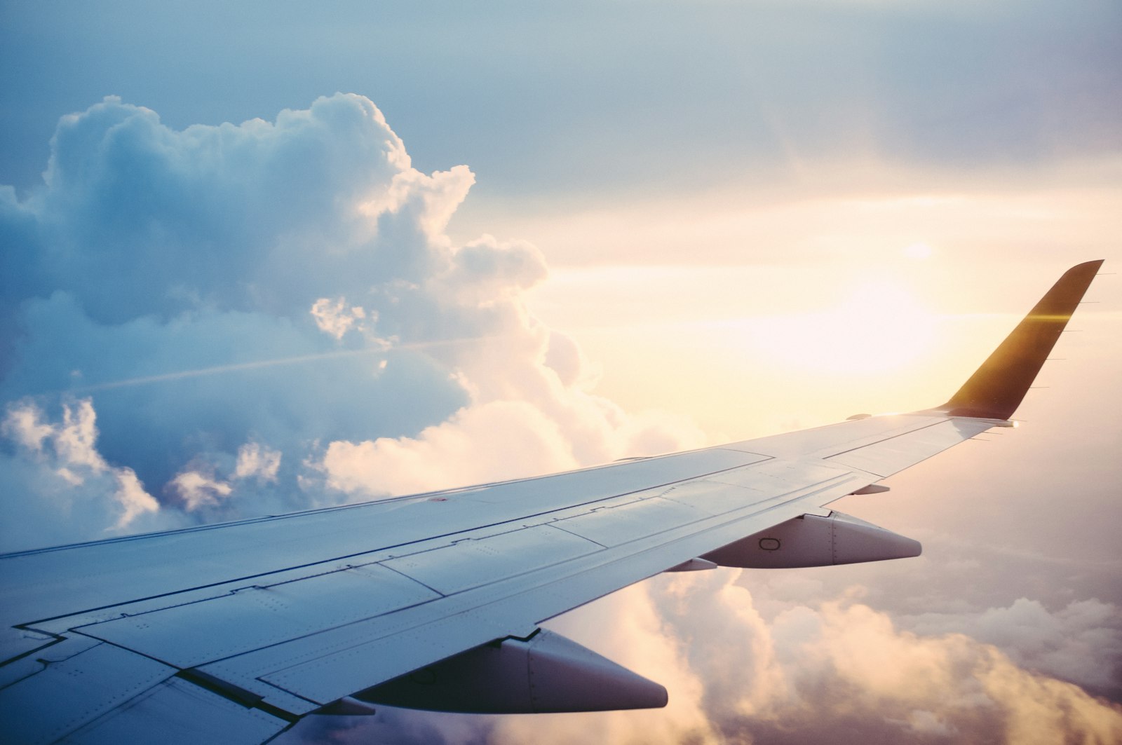 Airliner wing above the clouds at golden hour